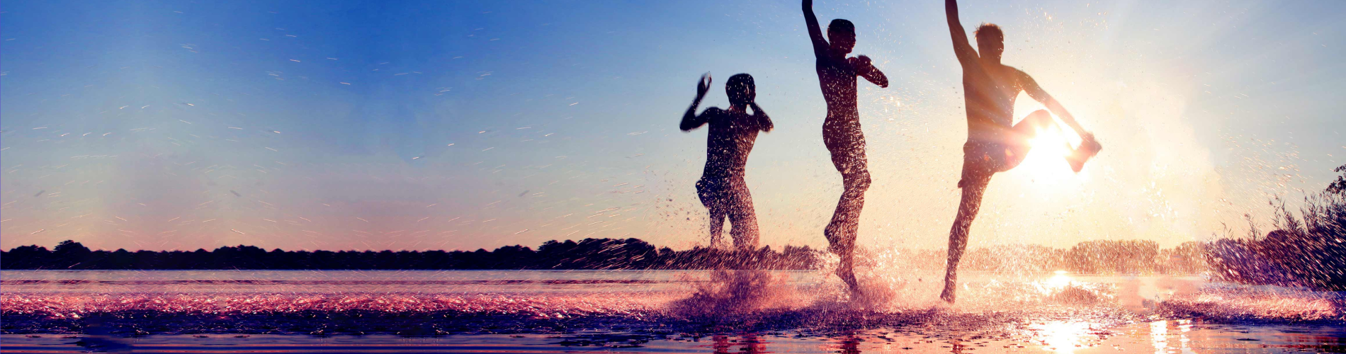 people playing on the beach and splashing in the water