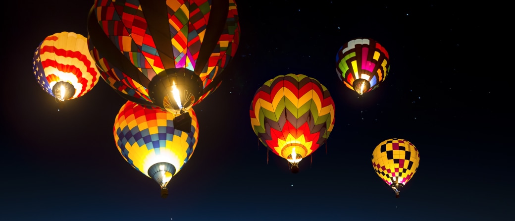 Ground view of hot air balloons filling the night sky in Albuquerque, New Mexico.