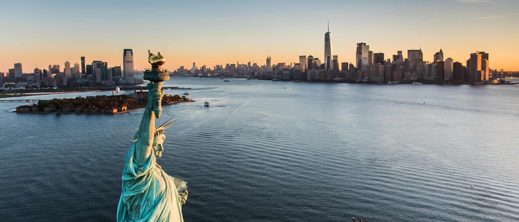 Aerial view of New York City from the harbor, with the Statue of Liberty in the foreground. A superimposed title reads: The 3 minute expert.