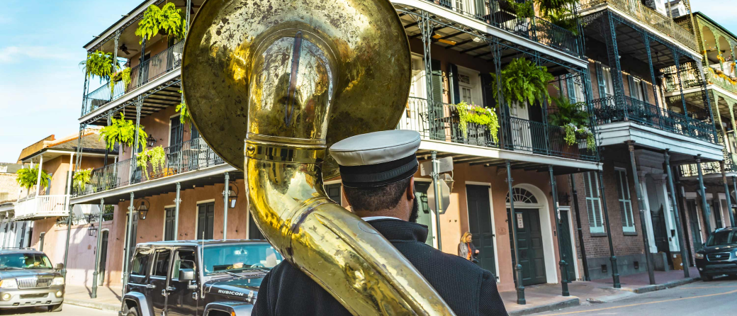 View from behind a tuba player of Bourbon Street in New Orleans, Louisiana.