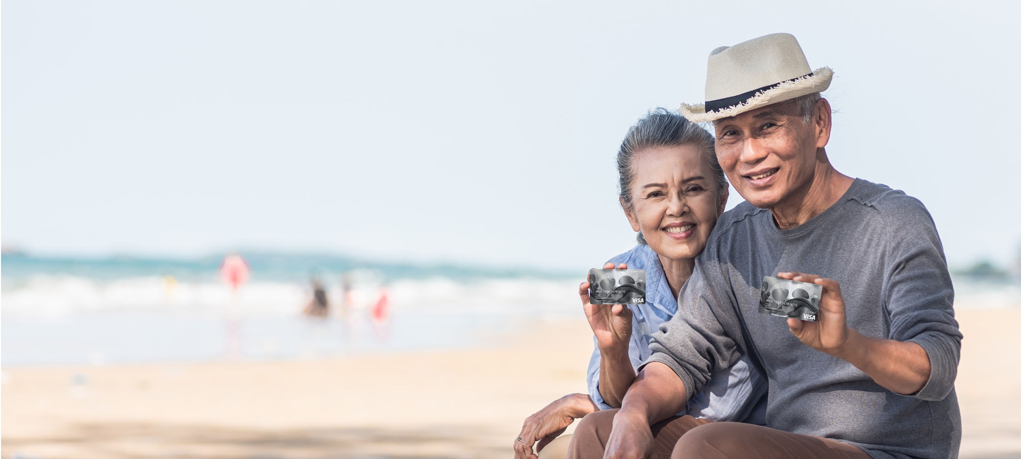 two people holding cards on a beach.