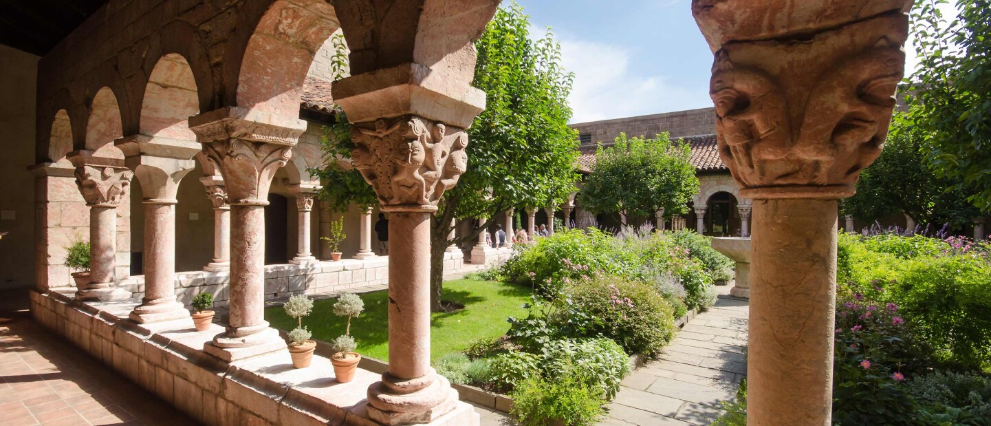 View from between marble columns looking out to the courtyard of The Cloisters in New York City, New York.