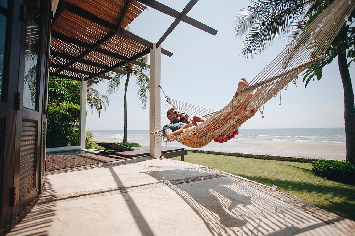 A couple relaxing in a hammock on the beach