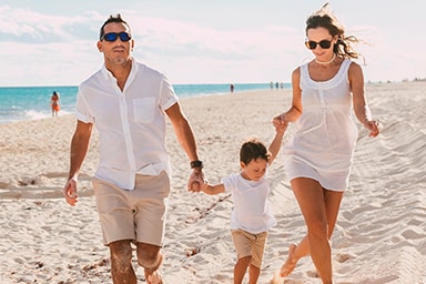 A family walks along the beach.