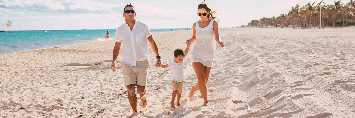 A family walks along the beach.