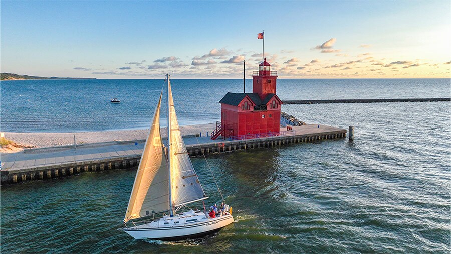 Sailboat passing Holland Harbor Light near Holland, Michigan