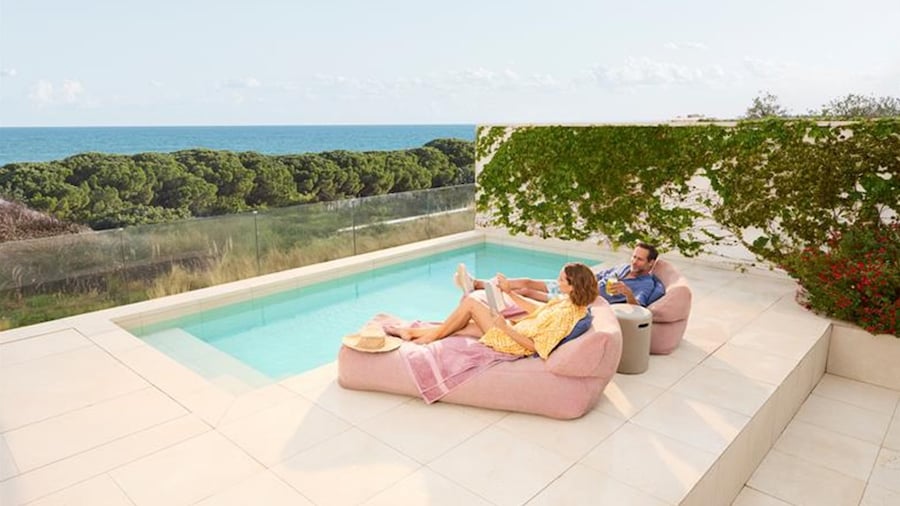 A couple enjoys poolside relaxation with a view.