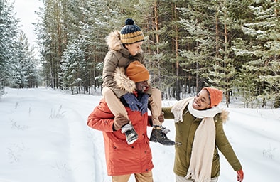 Une famille se promène dans les bois enneiges