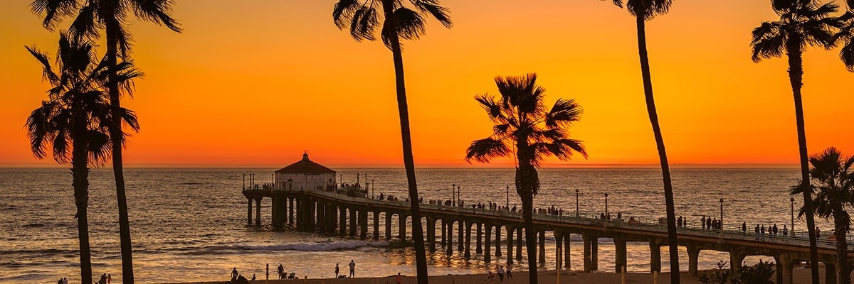 A scenic beach pier at sunset.