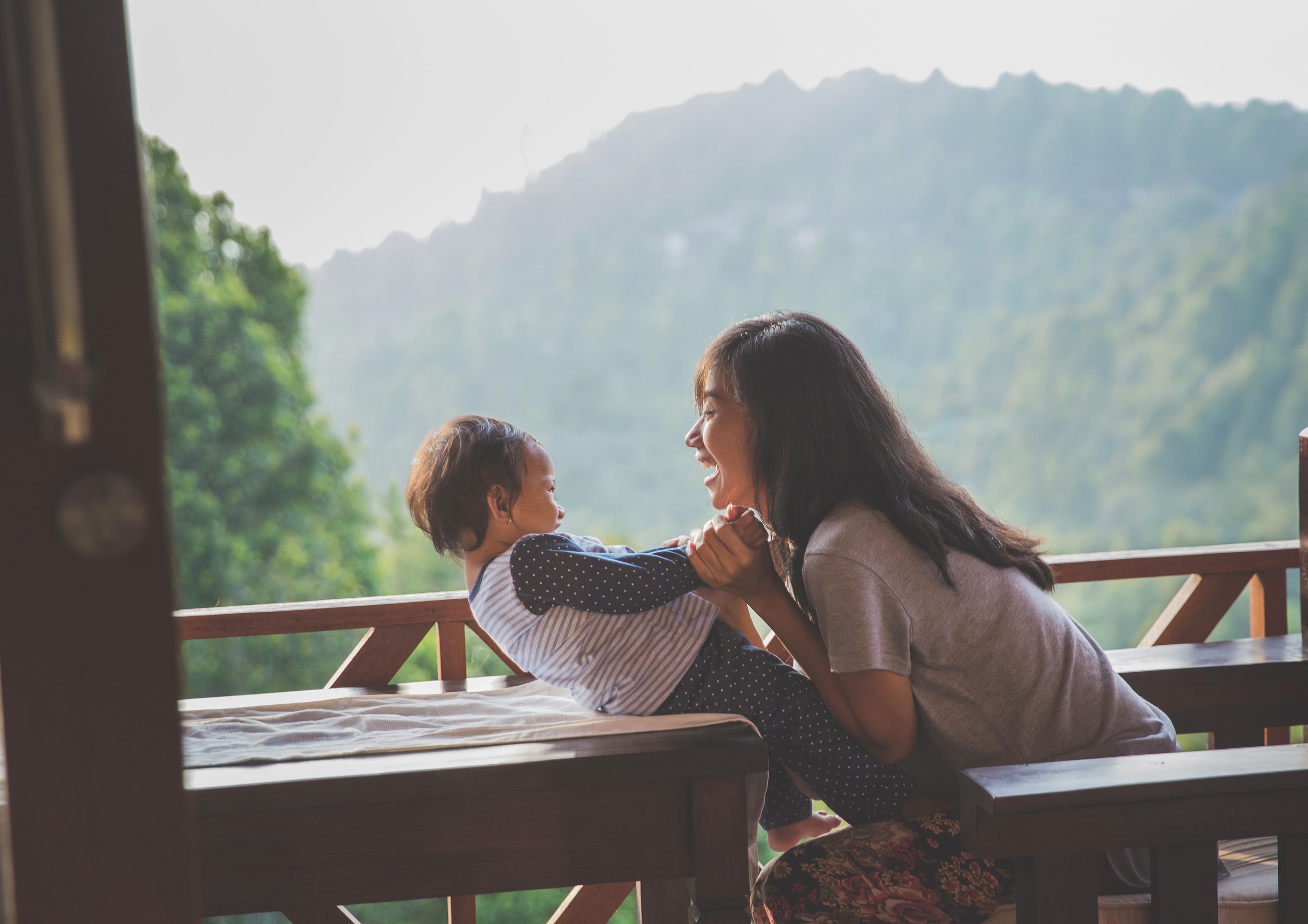 a mother leaning in and playing with a child