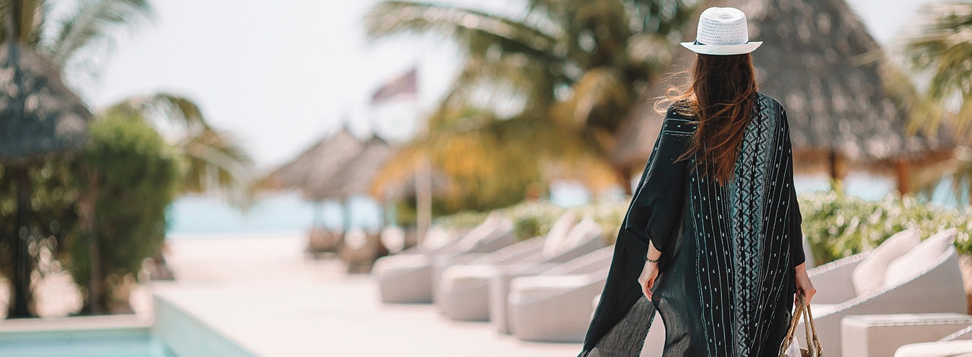 The view from a room of a brick-clad hotel room, looking out over a palm-fringed beach with a skate park in the centre.  