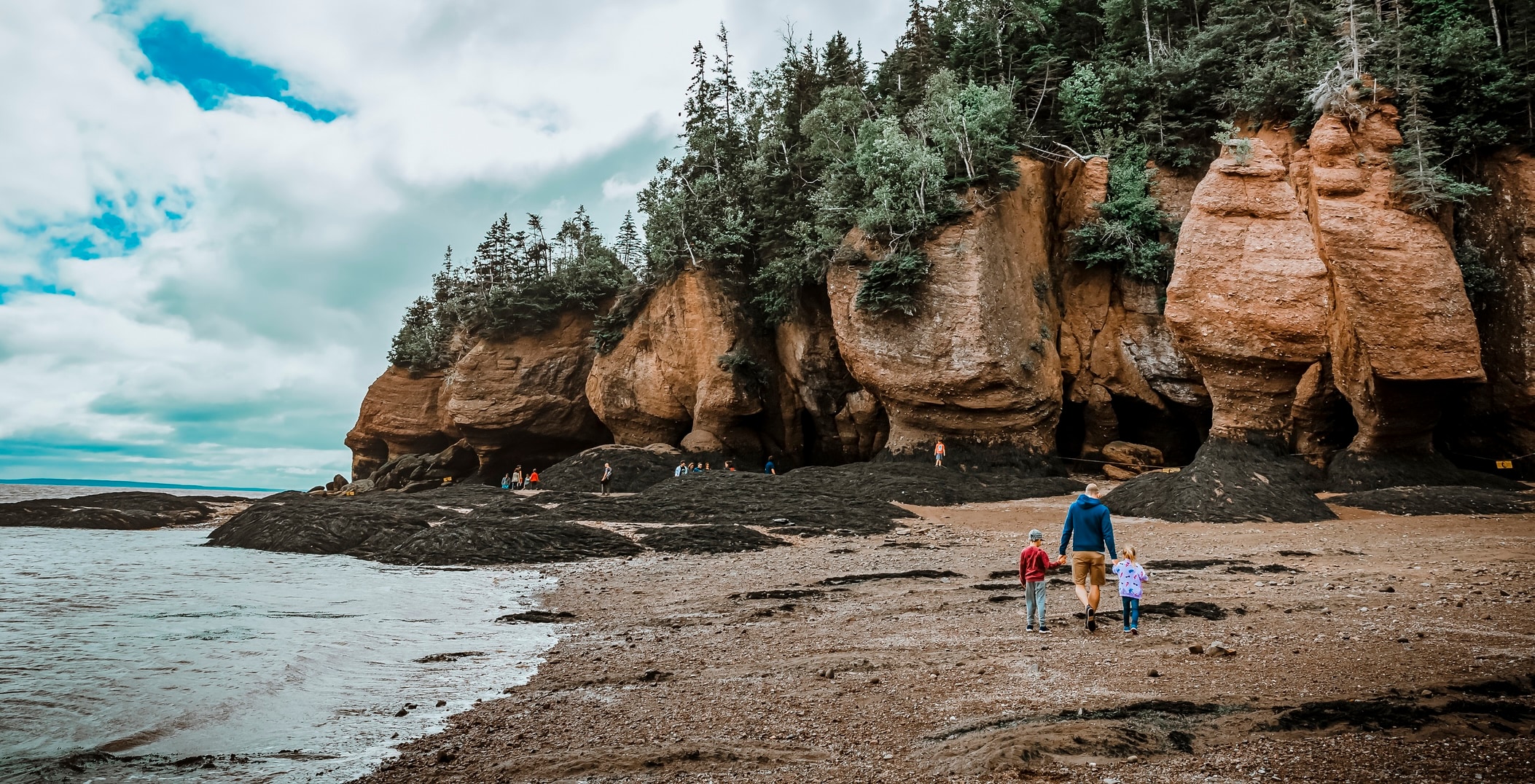 Father walking with his children on the beach