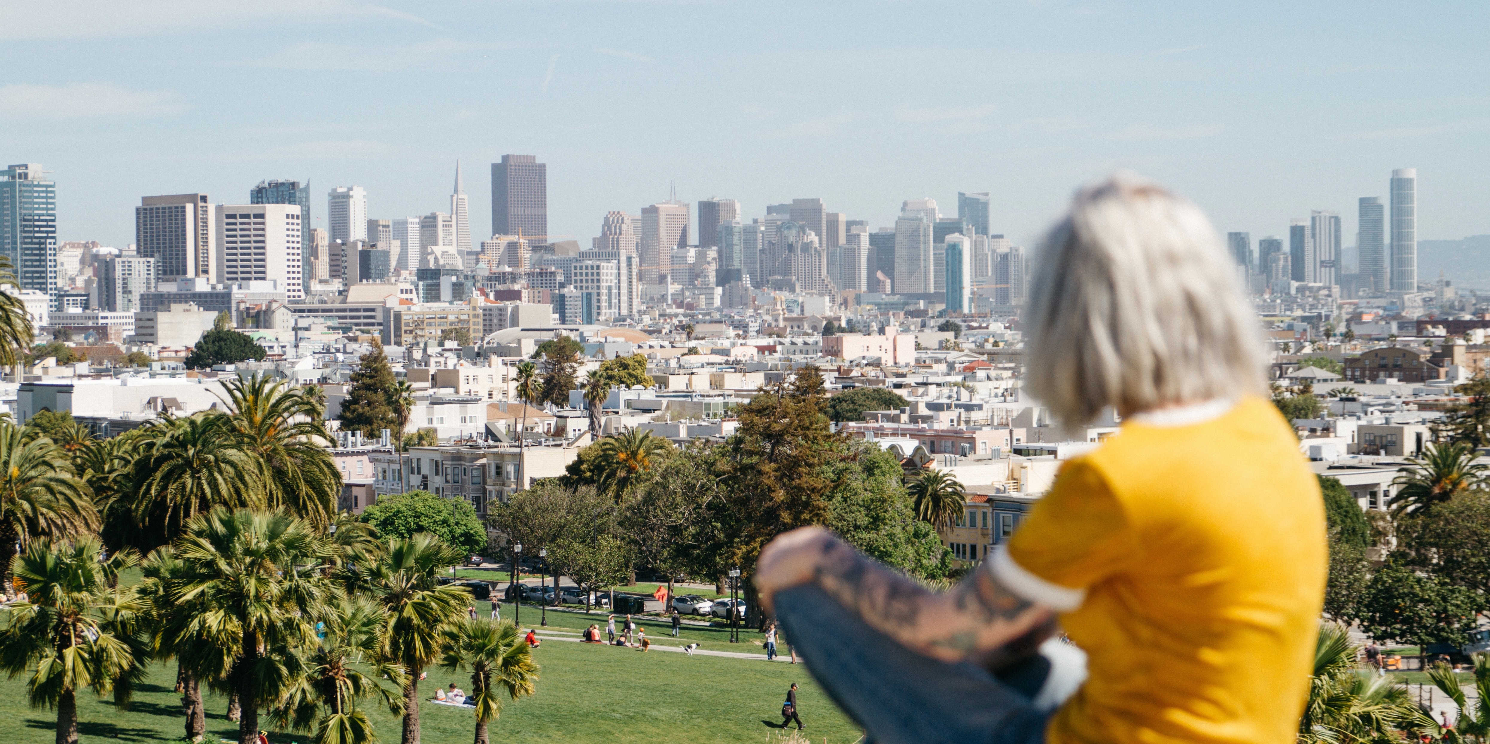 Woman sitting on hill overlooking San Francisco