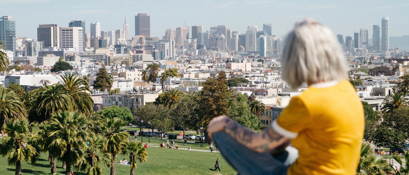 Woman sitting on hill overlooking San Francisco