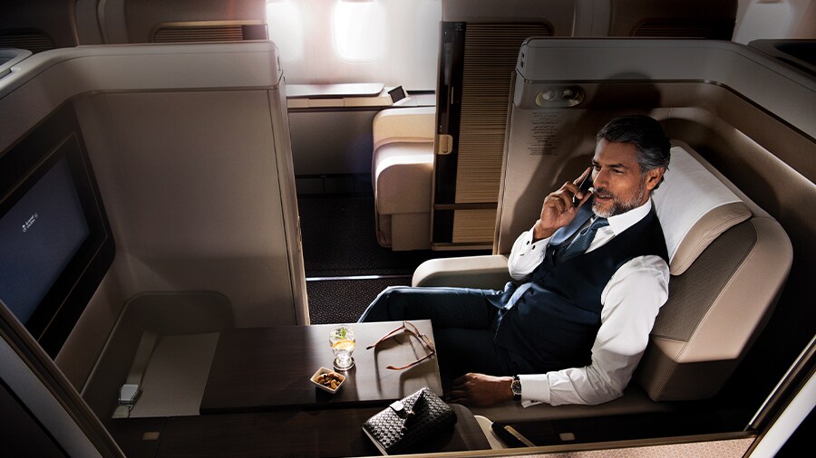 A person sitting in an airplane talking on the phone