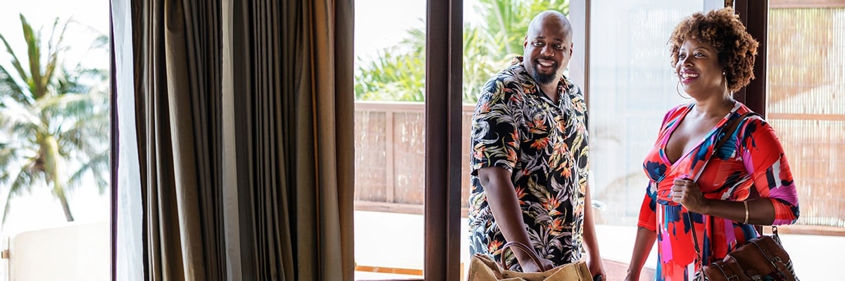 Couple entering a tropical hotel room.