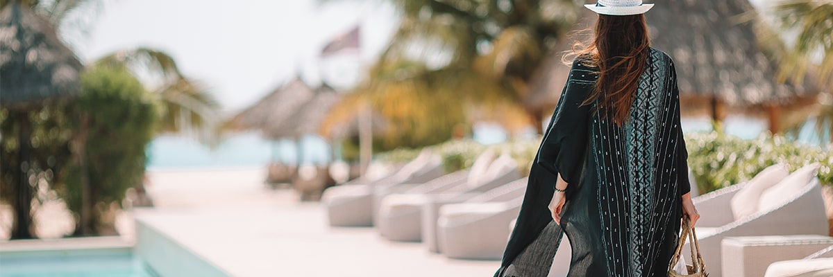 A woman walking along the side of a swimming pool