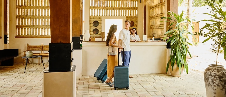 A couple with their luggage checks into an All-inclusive resort.