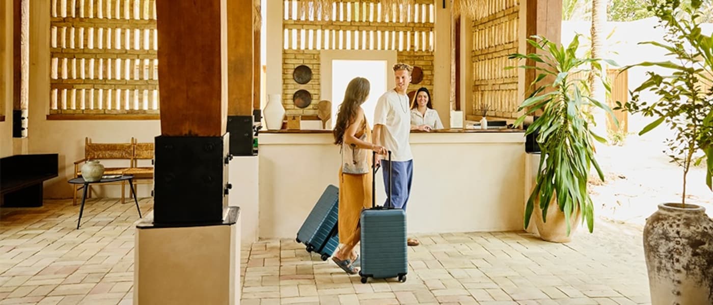 A couple with their luggage checks into an All-inclusive resort.