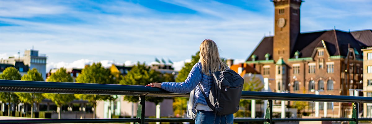 Woman on a bridge looking over the water