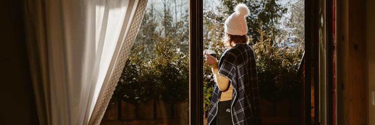 Woman enjoying hot cup tea looking at snowy mountains