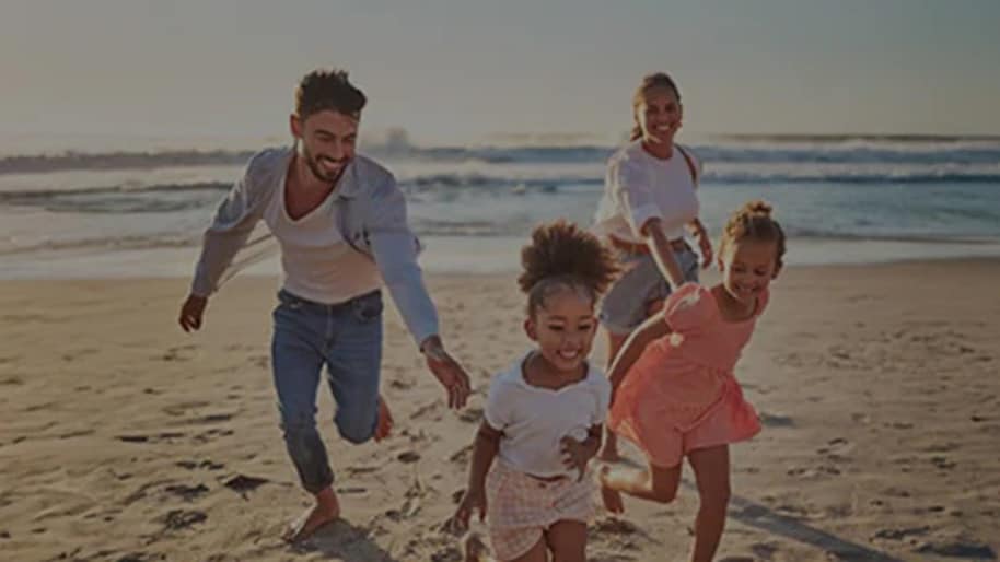 Family running on a beach.
