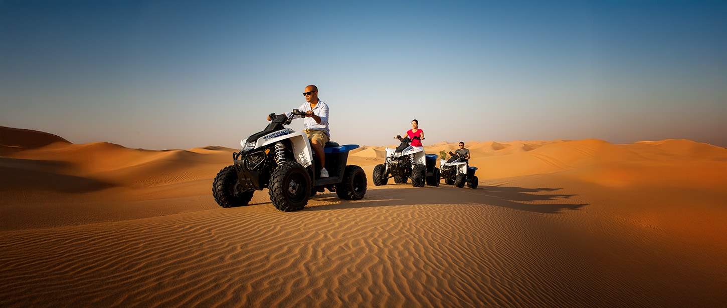 A group of people riding atvs in the desert