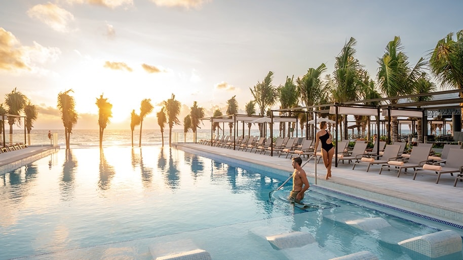 A sunset view of a pool at Hotel Riu Palace Kukulkan in Cancun.