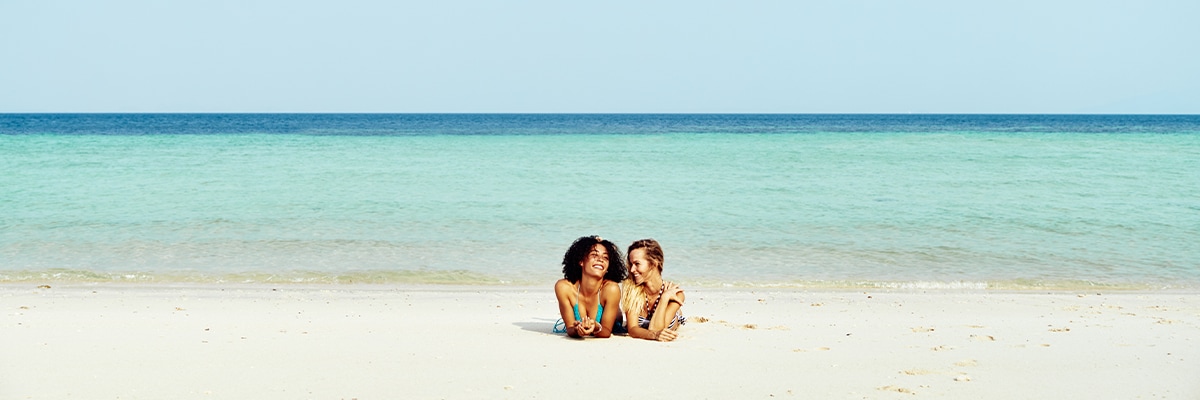 Two women lying on a beach