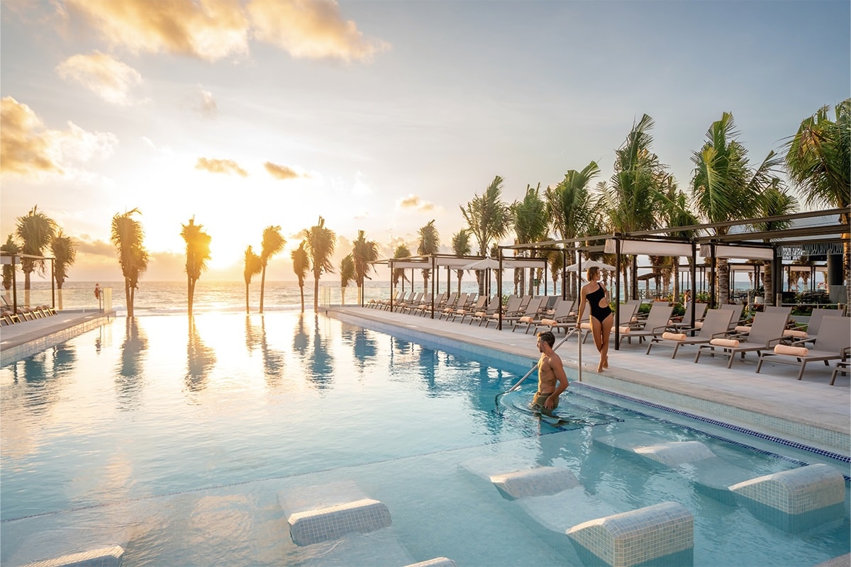 A sunset view of a pool at Hotel Riu Palace Kukulkan in Cancun.