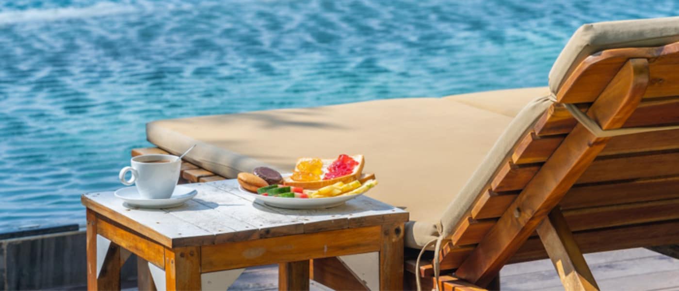 Fruit, tea and lounge chair by pool