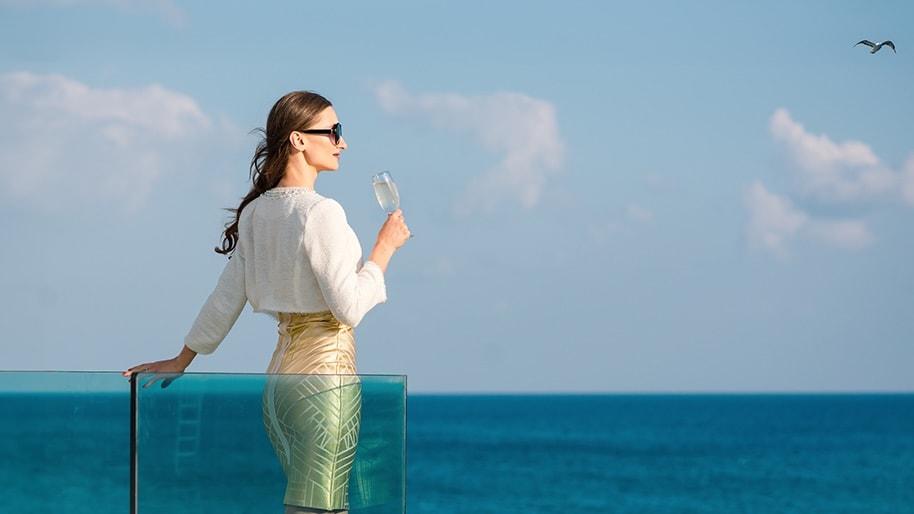 A woman in sunglasses looks out at the ocean view.