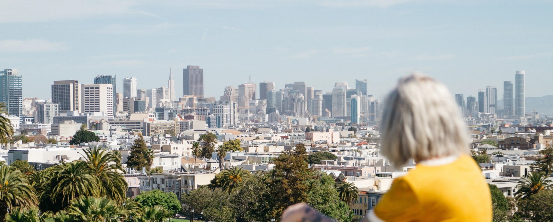Woman sitting on hill overlooking San Francisco