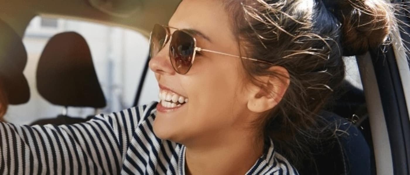 Two friends wearing sunglasses in their rental car.