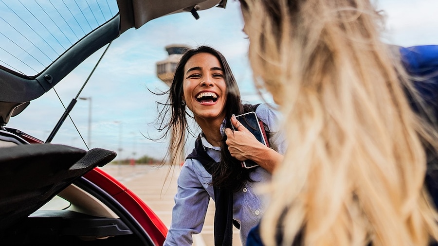 Two friends pick up their Hertz car rental.