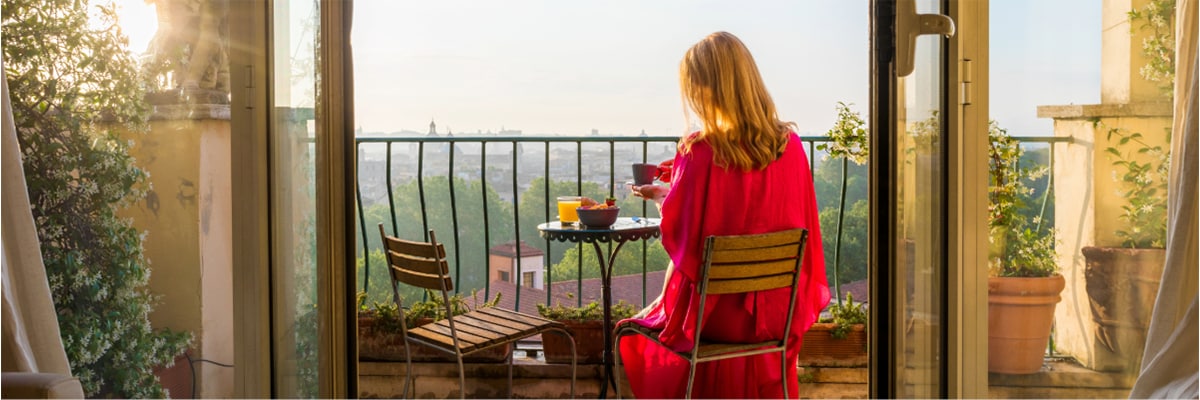 Woman relaxing having breakfast on balcony