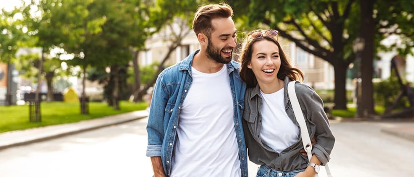 A couple laughs as they walk from their hotel.