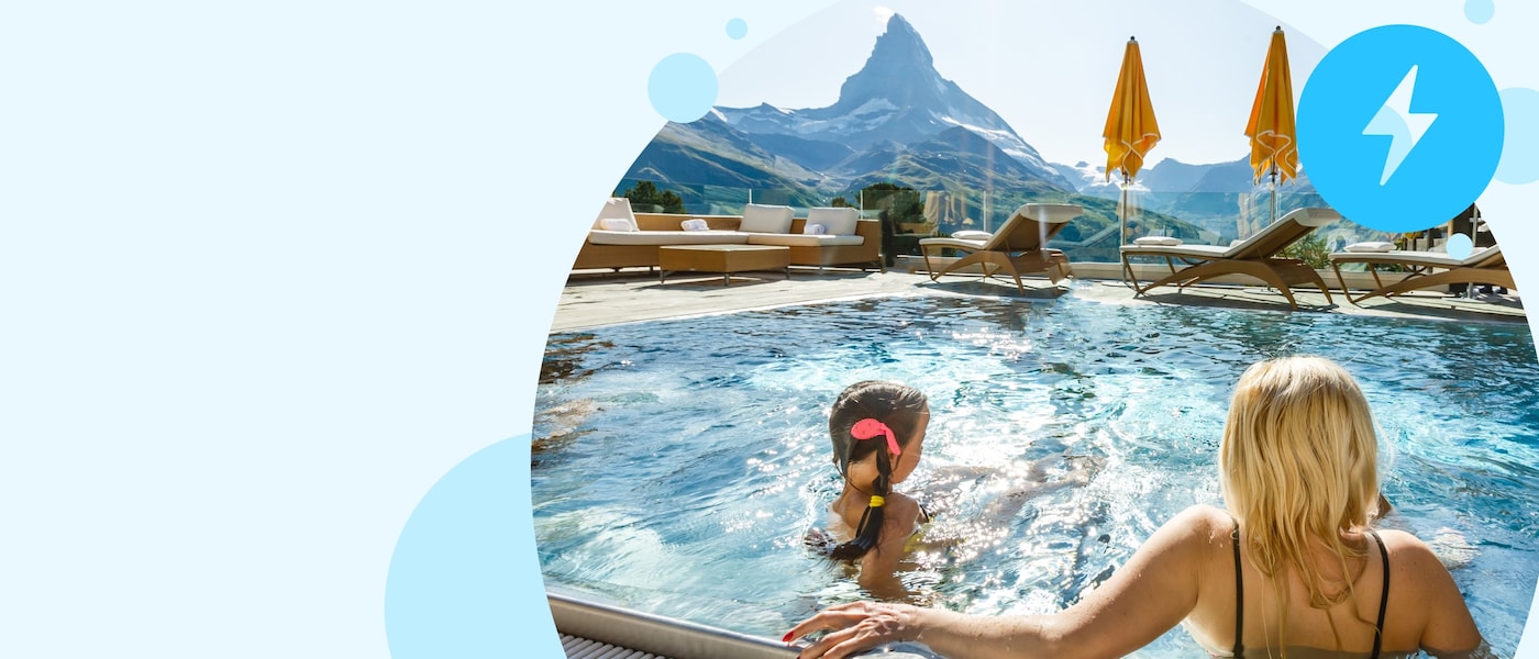 A woman and a child sit in a pool with a view of the Matterhorn in Switzerland.