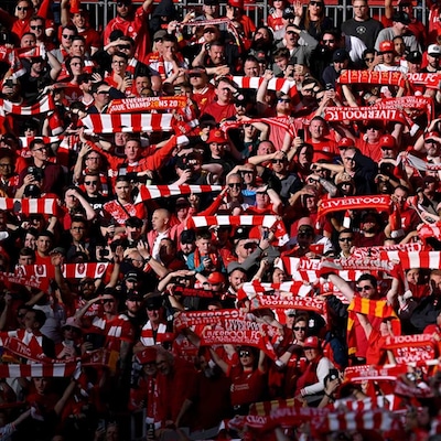 Liverpool FC supporters cheer their team in a sea of red
